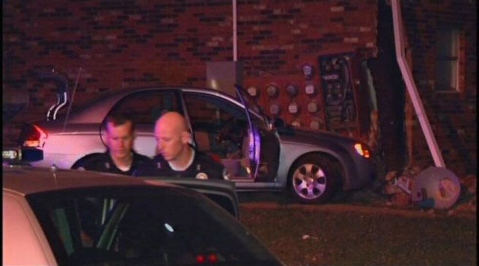 The car crashed into the side of the apartment.