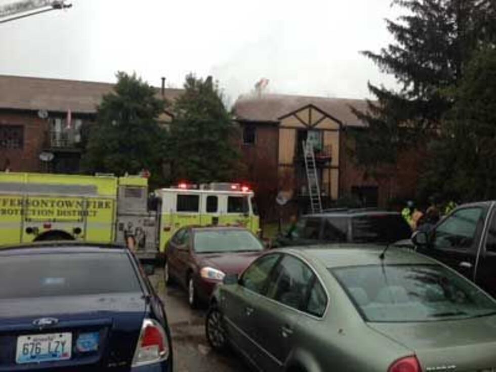A ladder rests against the third floor of the apartment building.