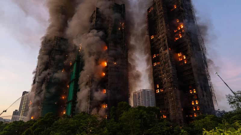 FILE - Smoke rises after a fire broke out at Wang Fuk Court, a residential estate in the Tai...