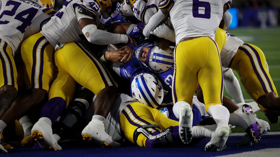 Kentucky quarterback Kenny Minchey fights in the end zone for a touchdown on the final play...