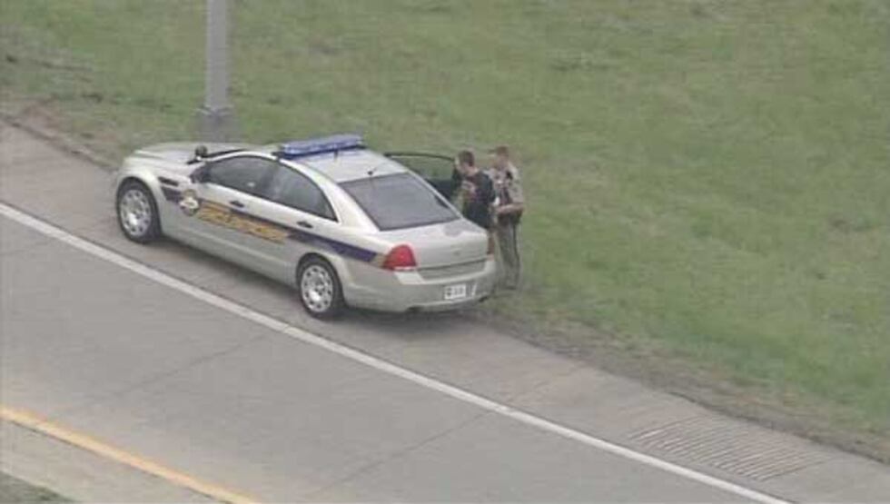 The driver being placed into a police car.