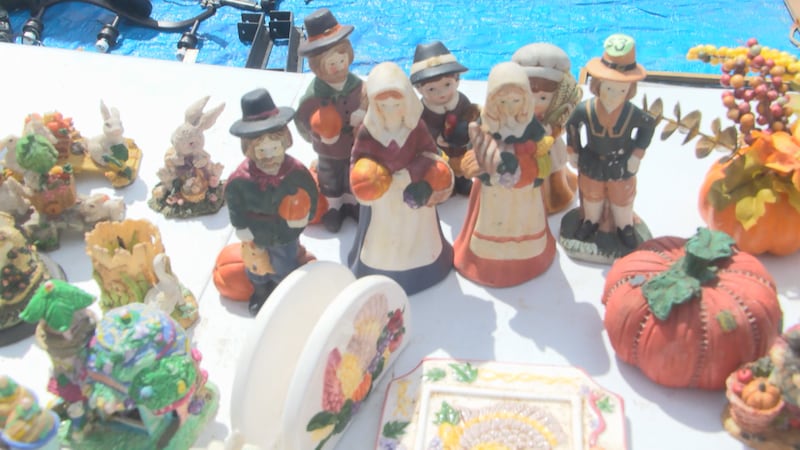 figurines and decorations sit atop a yard sale table