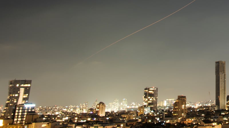 A projectile streaks through the sky over central Israel during an Iranian missile attack,...