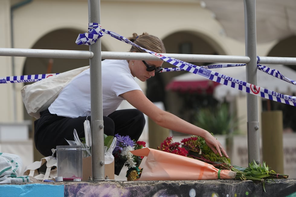 Shenna McClean lays flowers at a memorial at Sydney's Bondi Beach, Monday, Dec. 15, 2025, a...