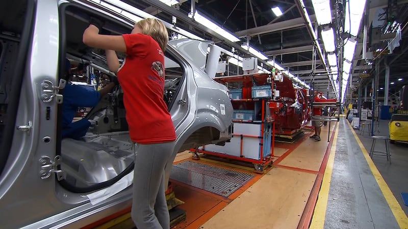 A worker at an American car manufacturer works on a vehicle coming down the assembly line. The...
